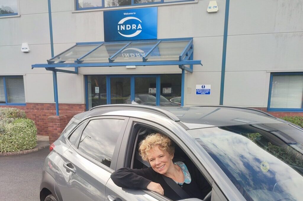 Indra staff member in Kona outside company building