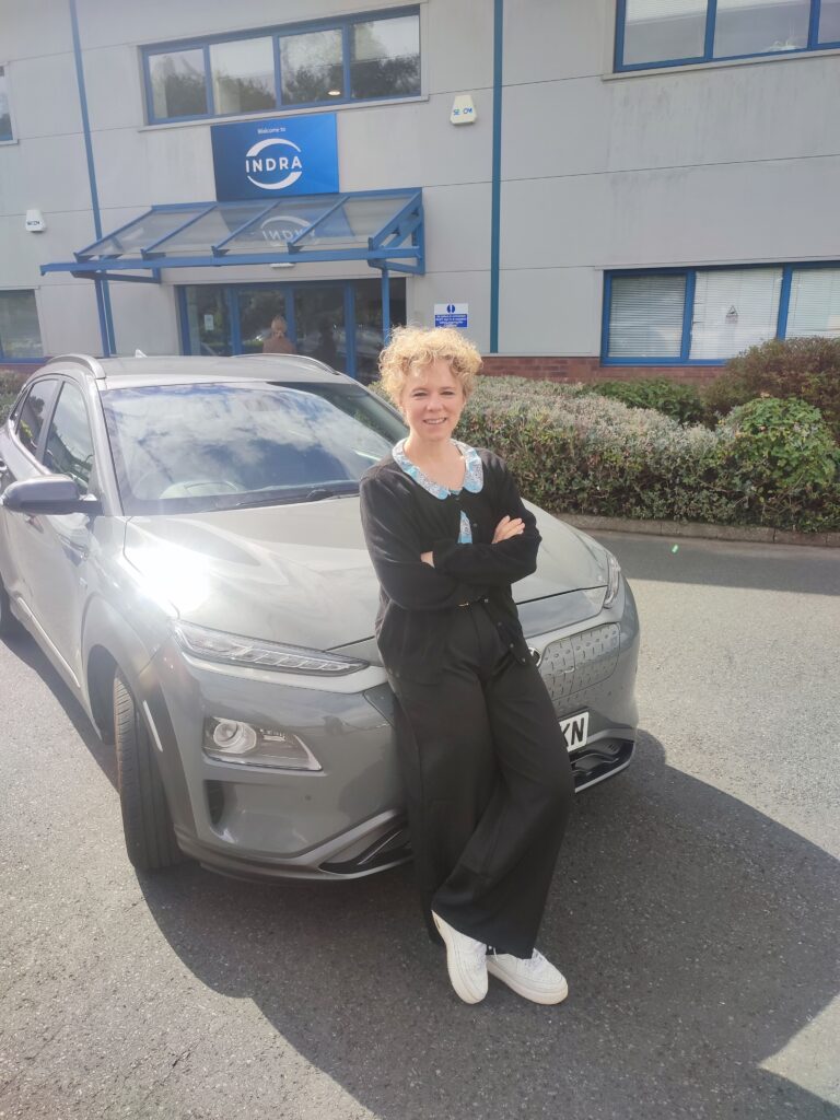 Indra staff member in front of electric Kona