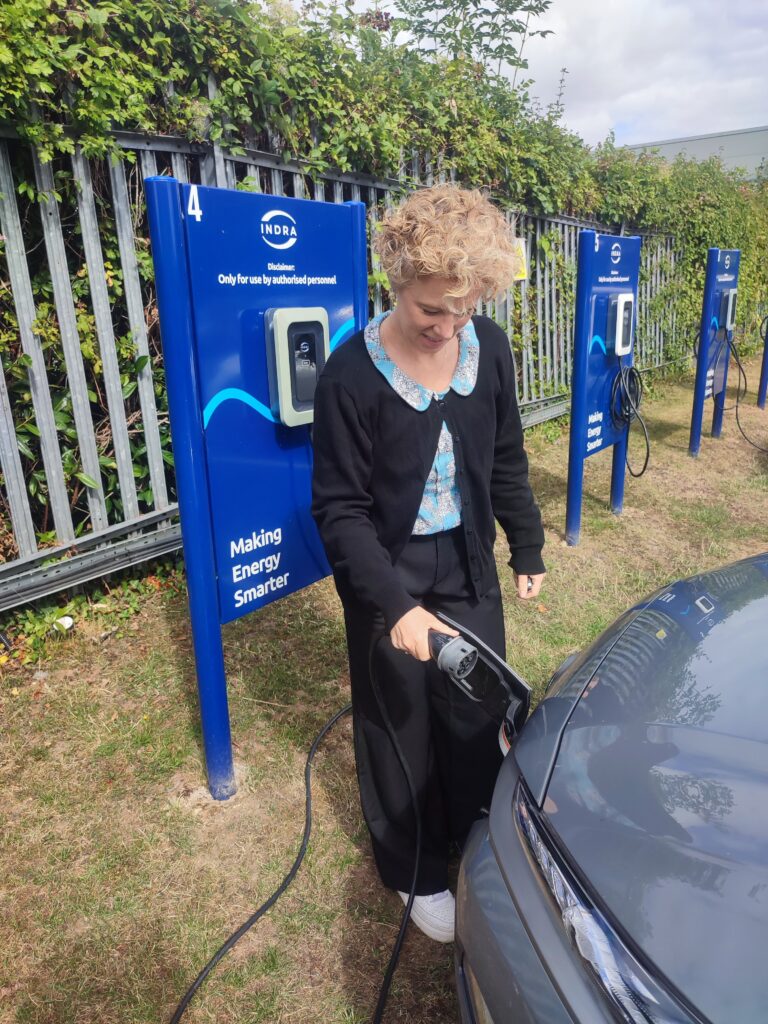 Indra staff member using car charger for EV Kona