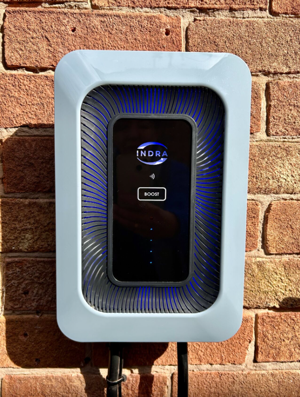 An Indra Smart LUX charger on a brick house wall