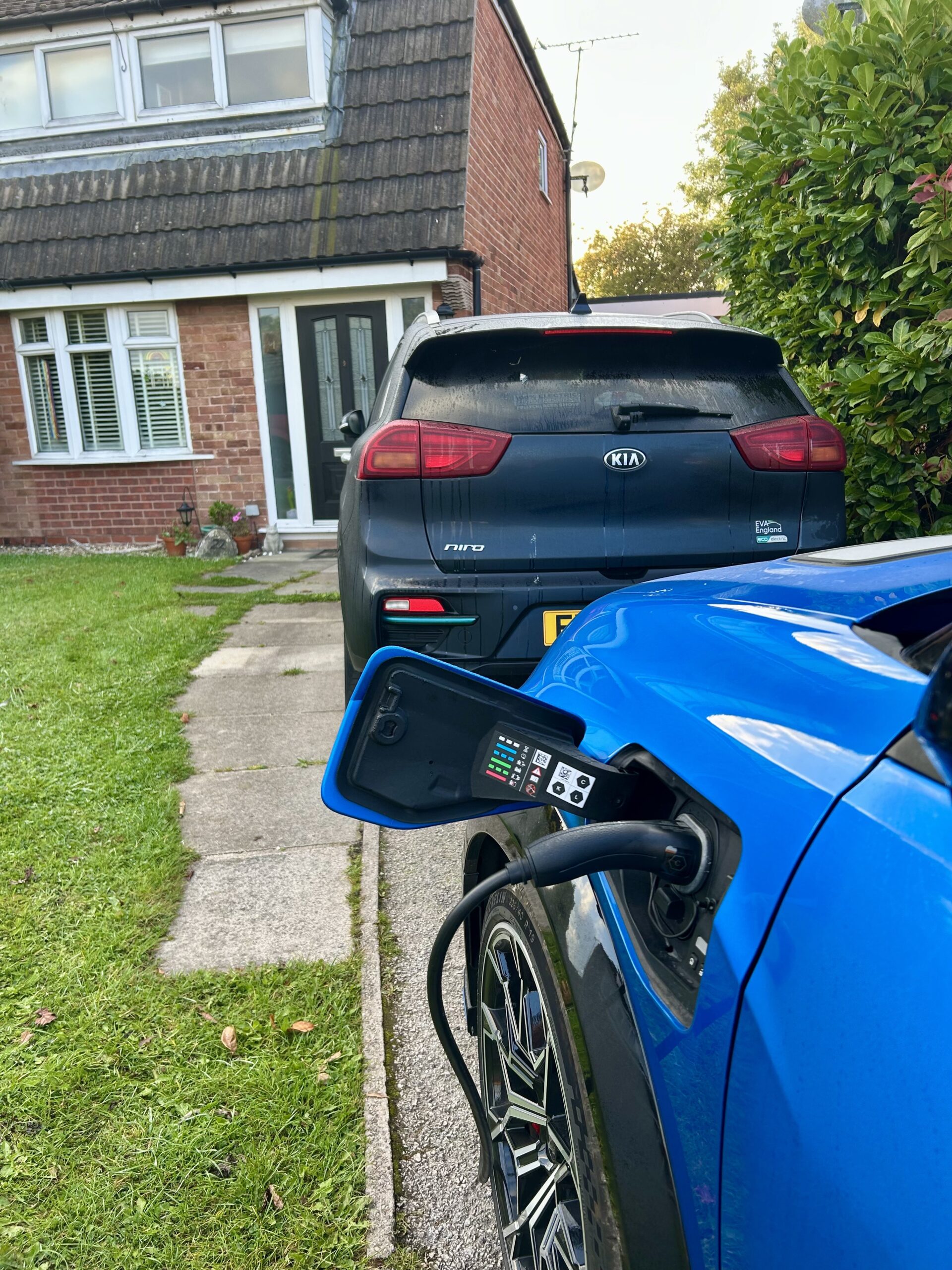 Car plugged into a charger and charging on a driveway