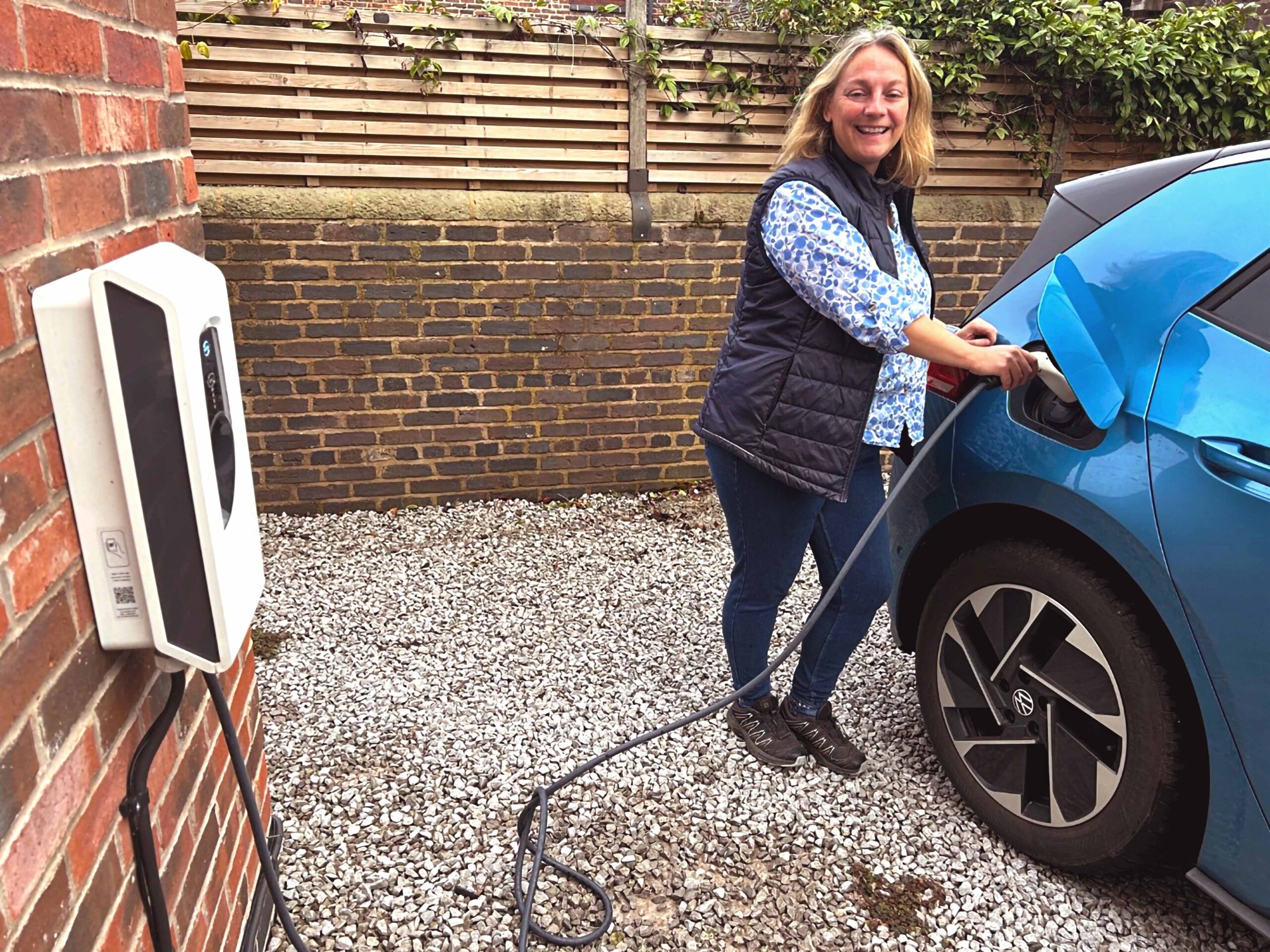 Woman plugging in her EV to the Smart PRO charger on the wall
