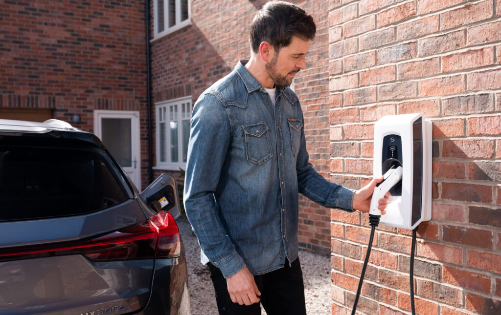 Man plugging his EV into a wall-mounted Indra PRO